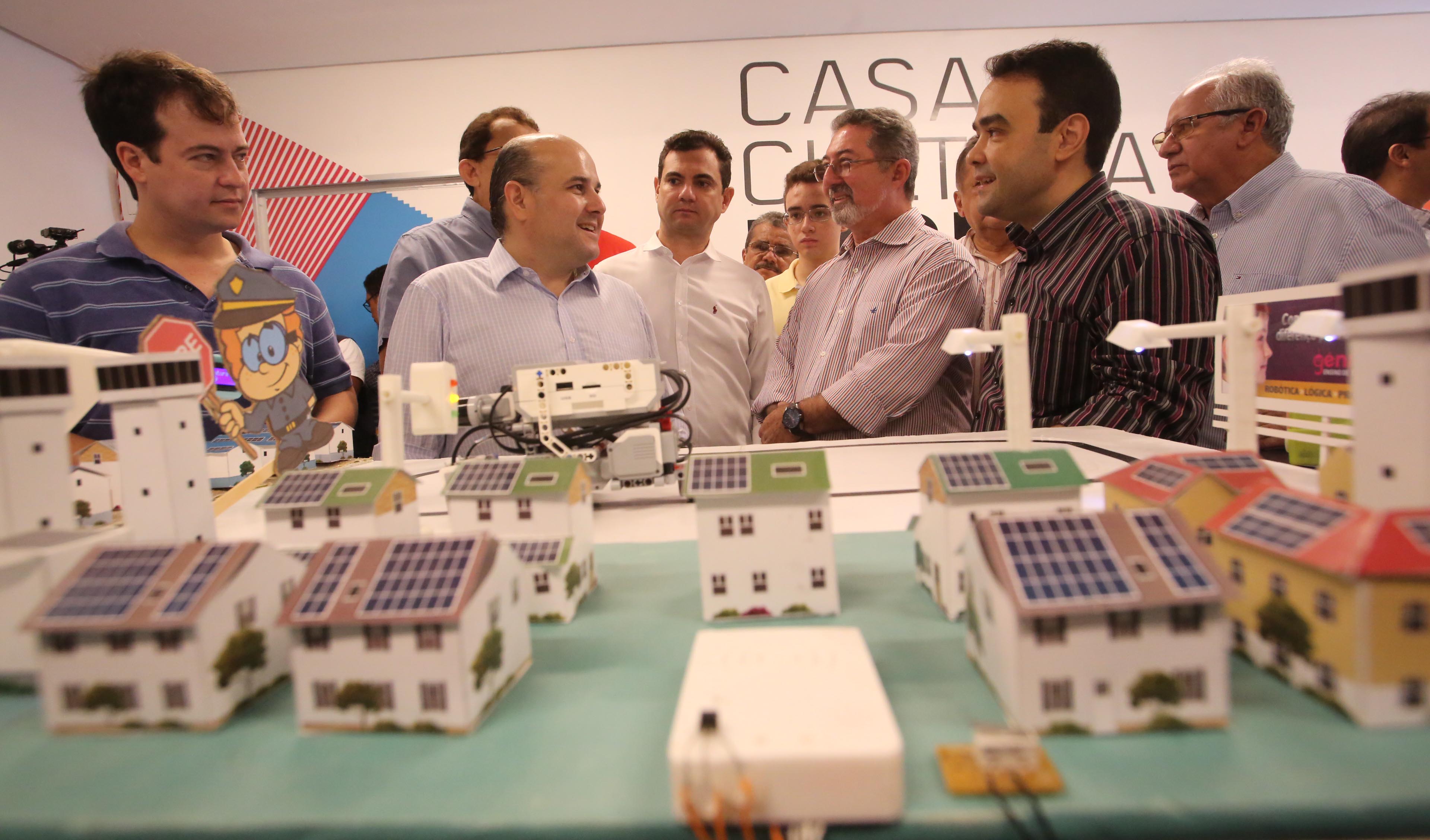 prefeito roberto claudio observa uma bancada com vários brinquedos eletrônicos em cima dela